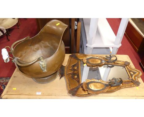A beaten shaped copper framed wall mirror, 70 x 49cm, together with a matching pair of candle wall sconces, and a helmet shap