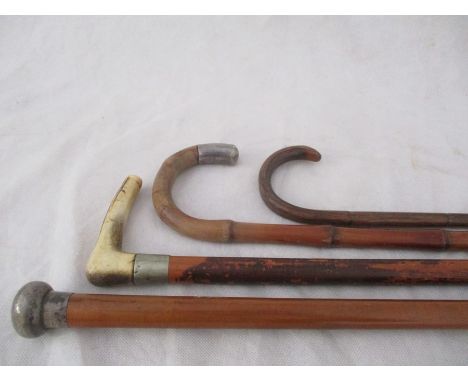 A silver mounted cane, silver topped walking stick and two others