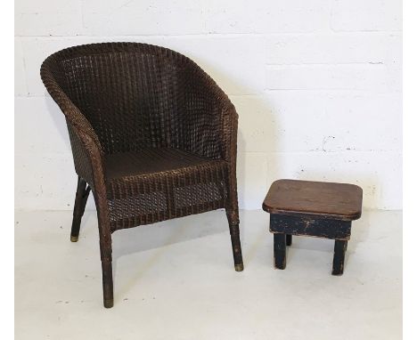 A Lloyd Loom chair with brass feet marked Feb 34 along with a small vintage stool