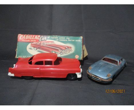 A tin plate friction driven Jaguar XK-E made in Japan and a boxed Marx Toys friction motor plastic Cadillac car.