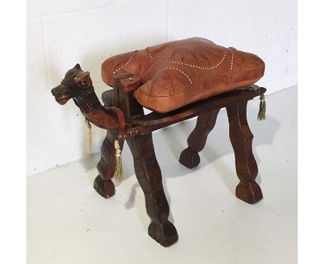 A vintage camel stool with leather seat and carved frame