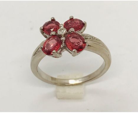 An 18ct white gold garnet "petal" ring with small central diamond