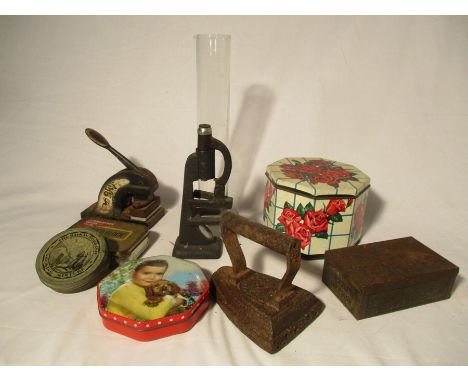 A collection of miscellaneous items including vintage tins, cast iron stamp, microscope ( A/F) etc.