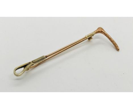 A 9 ct gold stock pin in the form of a hunting crop, weight 3.9g