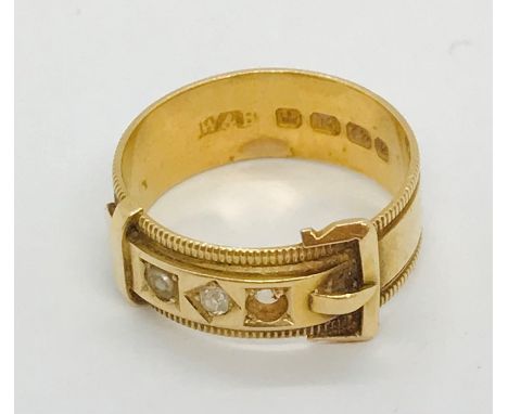 An 18ct gold buckle ring with single diamond flanked by two seed pearls ( 1 missing), weight 4.6g