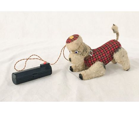 A battery operated Scotty dog with tartan coat. Light up eyes and movable legs and tail