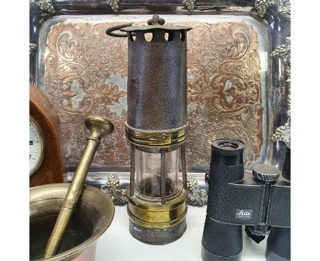 A miners lamp, a mantle clock, in an inlaid lancet case, a pair of Leitz binoculars, a pestle and mortar, and a silver plated