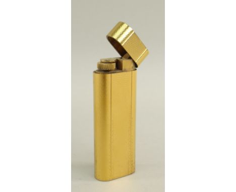 CARTIER GOLD PLATED CIGARETTE LIGHTER with oval section and engine turned decoration Condition: dent to top edge, general wea