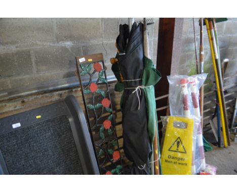 A bundle of various parasols, garden tools and a bench back