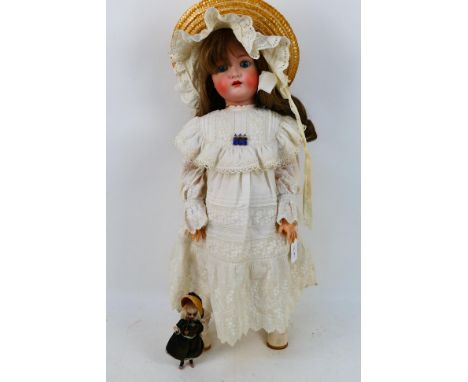 Simon & Halbig - A Simon and Halbig for Kammer and Reinhart doll. The doll has a card pate, a modern human hair wig, striated