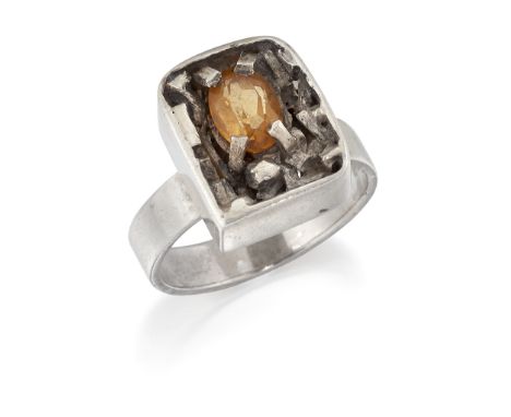 NORMAN CHERRY - A SCOTTISH MID-CENTURY MODERNIST SILVER CITRINE RING, an oval-cut citrine within a heavily textured and pierc