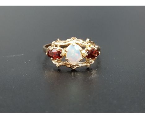 OPAL AND GARNET RINGthe central oval cabochon opal flanked by oval cut garnets, in pierced and shaped setting, on nine carat 