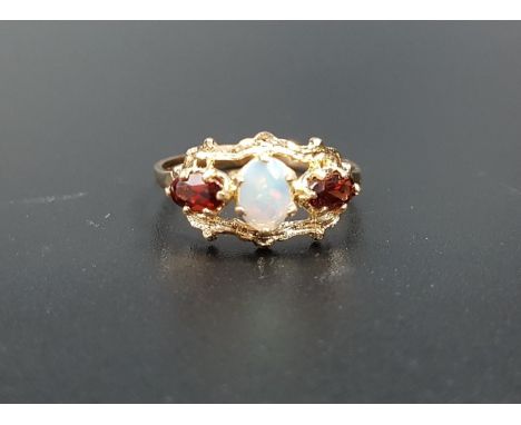 OPAL AND GARNET RINGthe central oval cabochon opal flanked by oval cut garnets, in pierced and shaped setting, on nine carat 