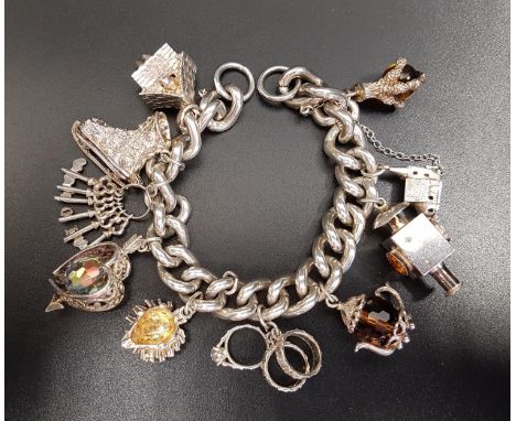 HEAVY SILVER CHARM BRACELETthe curb link bracelet with a good selection of larger sixed charms including an ice skate, a hedg