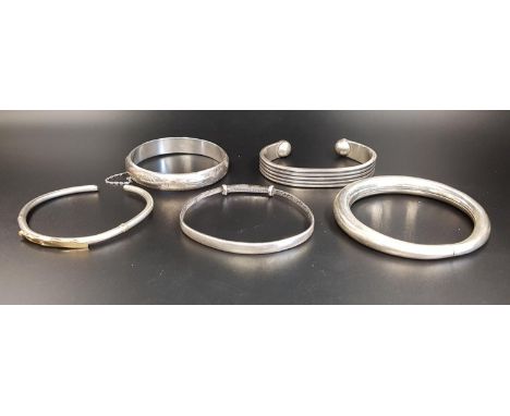 FIVE SILVER BANGLEScomprising one with nine carat gold detail; a Japanese Meiji Period expanding bangle with character and mo
