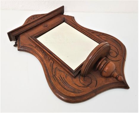 EDWARDIAN OAK FRAME SHIELD SHAPE HALL MIRRORwith carved decoration around a square beveled plate with a small shelf below, 59