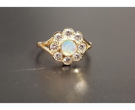 PRETTY OPAL AND DIAMOND CLUSTER RINGthe central round opal in eight diamond surround totaling approximately 0.5cts, on nine c