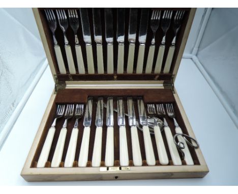 A cased set of twelve silver plated dessert knives and forks having cream handles, a fruit spoon and napkin ring