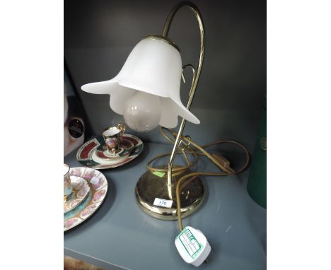 a brass bodied light with flower design shade