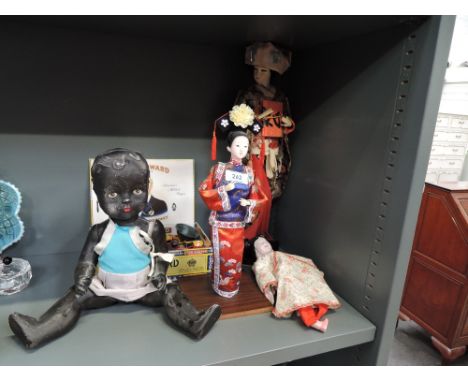 A mid 20th century composition black doll having fixed eyes and mouth and jointed body, two modern oriental dolls and a compo