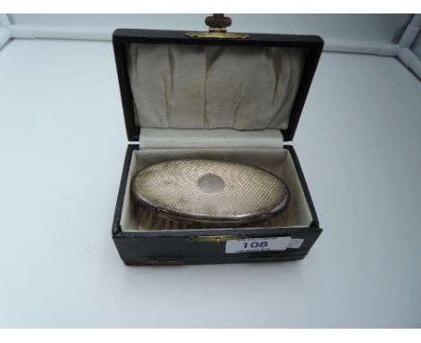 A small cased HM silver backed bush of oval form having engine turned decoration and plain cartouche
