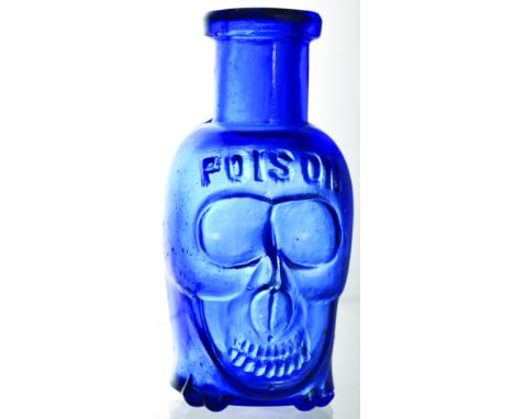 SKULL POISON. (DP pg 20) 2.75ins tall, blue glass heavily moulded as a skull standing on a crossed bones under the base base.