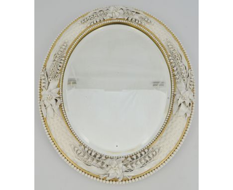 Porcelain mounted oval mirror, probably Belleek, basket weave moulded, beaded outline and applied bell flowers, 43cm x 34cm.