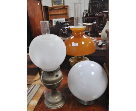 Two brass oil lamps and a globe shade (3)