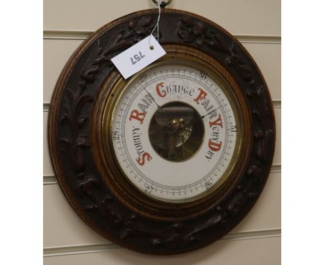 A Victorian carved oak aneroid barometer W.36cm