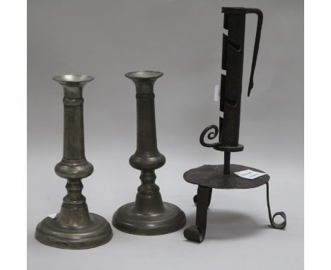 An 18th century French wrought iron adjustable candlestick and a pair of pewter candlesticks