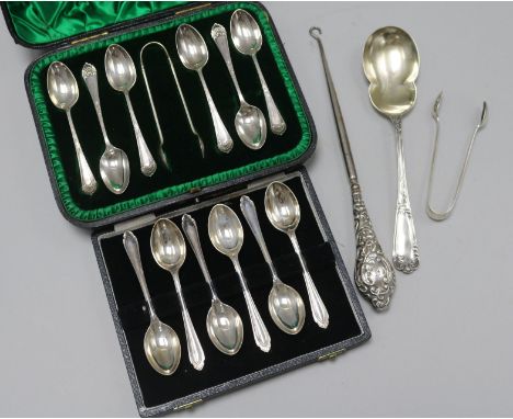 Two cased sets of six silver teaspoons, one with tongs, a silver serving spoon, silver handles button hook and a pair of silv