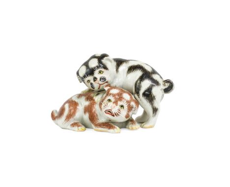 A Kutani Porcelain Dog Group, Meiji period, as two playing puppies with black and orange markings 16cm longProvenance: With I