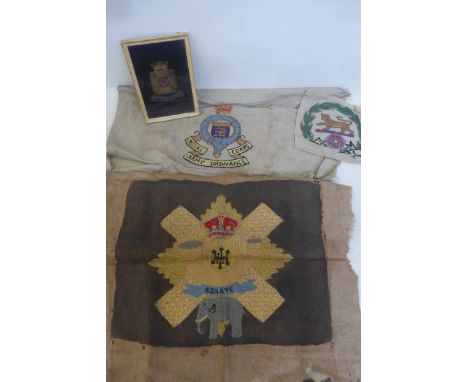 A framed and glazed bullion wire Wiltshire Regiment badge with three embroidered badges of the Hampshire Regiment, the Royal 