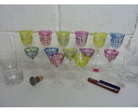 A part suite of Austrian Harlequin drinking glasses with overlaid coloured glass, cut bowls, knopped stems and star cut feet,