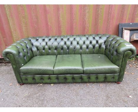 A modern three seater green leather button back sofa