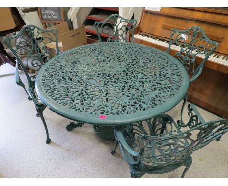 A modern green painted cast metal garden table with a set of four garden armchairs