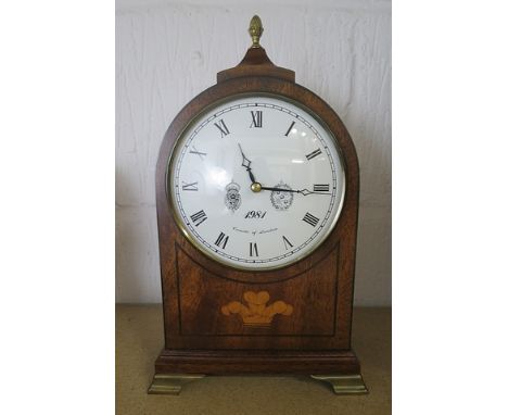 A Comitti of London mantel clock, the mahogany case inlaid with the Prince of Wales feathers to the front, and ebony stringin