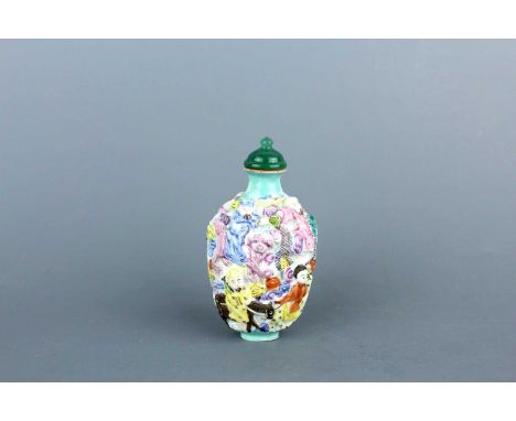 A Chinese famille rose ’Eight Immortals’ snuff bottle, QING DYNASTY late 19th century, moulded throughout the body with Eight