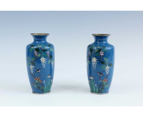 A pair of Japanese cloisonné enamel vases, early 20th century, each decorated with a bird perched on a vine with blooming flo