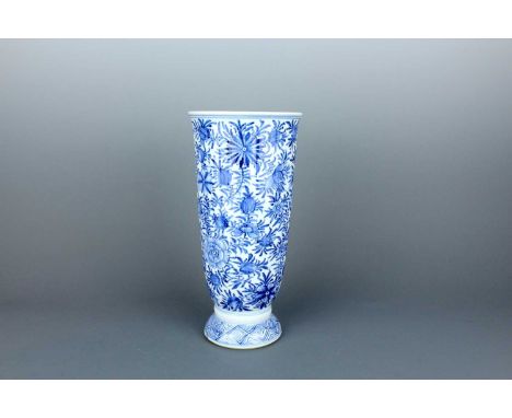 A Chinese blue and white tall beaker vase, Qing Dynasty, Kangxi period (1662–1722) The tall beaker-shaped body is moulded wit