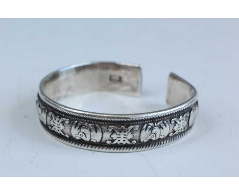 A Chinese silver bangle, late 19th to early 20th century. Decorated with stylised birds and the Chinese character shou (longe