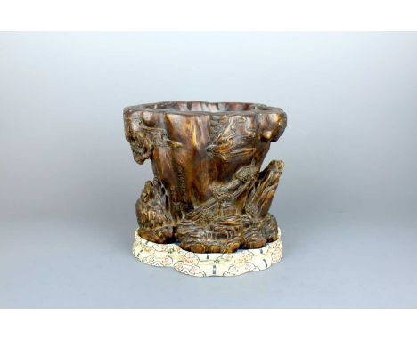 A Chinese wood-carved landscape brush pot, 19th or 20th century. Deeply carved with a continuous mountainous scene, dotted wi