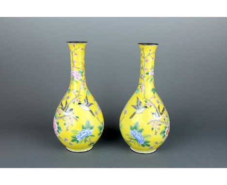 A pair of Chinese Canton yellow-ground enamel bottle vases, 20th century. Of pear-shaped form, each vase is richly decorated 
