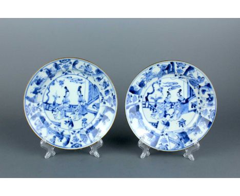 A pair of Chinese blue and white saucers, Qing Dynasty, Kangxi or Yongzheng period. Each is painted with two ladies chatting 