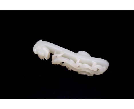 A Chinese white jade ‘dragon’ belt hook, 18th to early 19th century, intricately carved with a dragon’s head forming a hook a