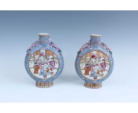 A pair of Chinese famille rose moon flasks, Qing dynasty, 19th century, each brightly painted with figural scenes in an inter