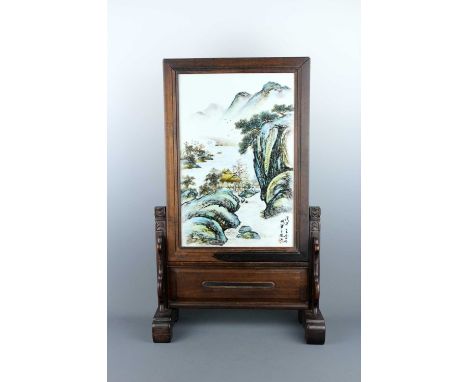 A Chinese hardwood table screen with an inserted ‘landscape’ plaque, 20th century. The rectangular plaque finely painted with