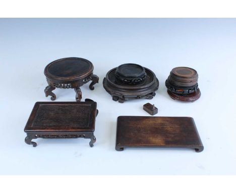 A group of Chinese wooden stands, comprising two square stands (one in the form of a scroll), a large raised stand and severa