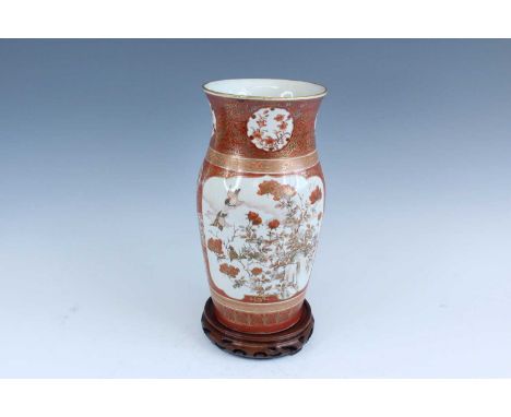 A Japanese Imari-style vase, 20th century. Decorated in gilt and iron-red with birds and flowers against a coral-red ground, 