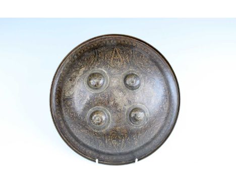 An Indo-Persian brass shield, 19th century, with with four raised bosses and engraved floral decoration, diameter 27cmGood co